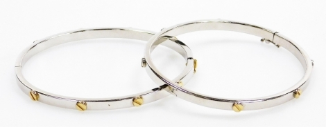 A pair of 9ct two coloured gold Cartier style bangles, set with screw decoration at intervals, each on a snap clasp, 16.4g.