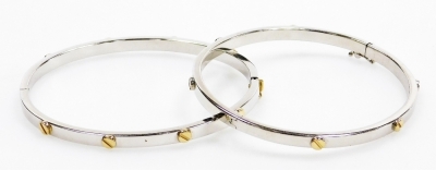 A pair of 9ct two coloured gold Cartier style bangles, set with screw decoration at intervals, each on a snap clasp, 16.4g.