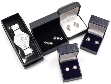 A group of earrings and jewellery, comprising a pair of silver three stone drop earrings, wave design clusters, rose gold coloured studs, heart shaped earrings and a wristwatch. (5)