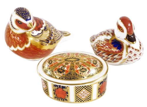 A Royal Crown Derby Imari porcelain paperweight, modelled as a Pheasant, another of a duckling, gold stoppers, printed marks, together with an old Imari porcelain oval trinket box and cover. (3)