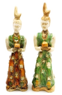 A pair of Chinese Tang style terracotta tomb figures, with brown, cream and green glazes, each holding a square parcel (AF), 38cm high.