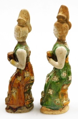 A pair of Chinese Tang style terracotta tomb figures, with brown, cream and green glazes, each holding a square parcel (AF), 38cm high. - 2