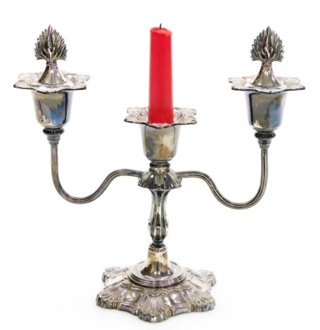 An Elizabeth II silver candelabra, the top with two flame shaped candle snuffers, the body heavily decorated with shells, scrolls, etc., Birmingham 1973, loaded, 26cm high, 30oz gross.