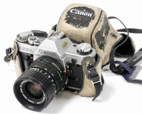 A Canon AE-1 camera, with a zoom lens FD35-70mm 1:3.5-4.5, cased. (AF)