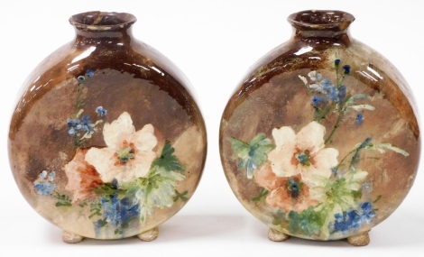 A pair of late 19thC Minton pottery moon flasks, painted with flowers against a brown ground, one bearing paper label for T Good and Company, London, Paris Exhibition 1878, 19.5cm high. (AF)