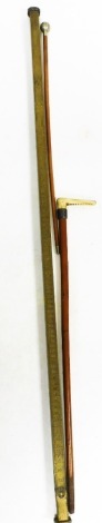 A Thompson Brothers Billesdon brass measuring stick, 136cm long, a West Indian Assaye swagger stick, and a Swaine and Co London horn handled walking stick. (3)