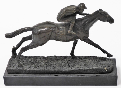 A bronze figure of a jockey and racehorse, on a naturalistic ground, raised on a black marble base, 49cm wide.