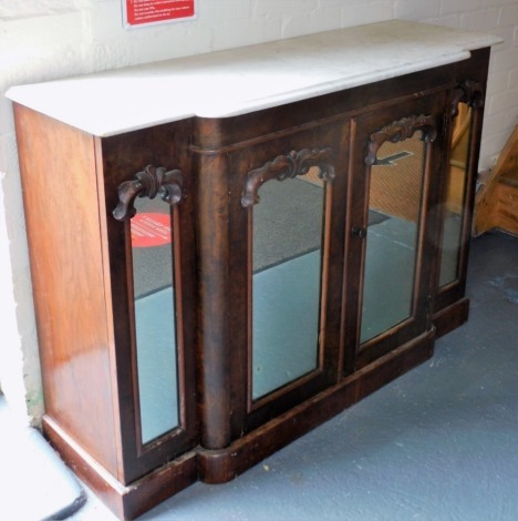 A Victorian walnut and marble topped breakfront sideboard, the mirrored front having two doors opening to reveal a single shelf, raised on a plinth base, 85cm high, 122cm wide, 40cm deep.