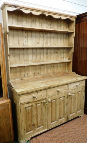 A Victorian style pine kitchen dresser, with a three shelf plate rack, above three drawers over three panelled cupboard doors, raised on bracket feet, 208cm high, 152cm wide, 46.5cm deep.