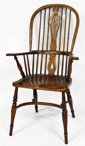 A Victorian ash and elm Windsor chair, with a vase shaped splat, solid saddle seat, raised on turned legs united by a crinoline stretcher.