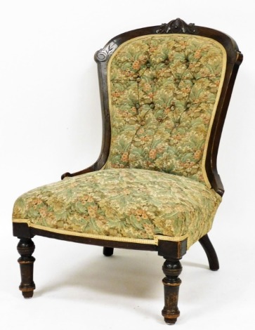 A Victorian walnut spoon back nursing chair, upholstered in button back floral fabric, raised on turned legs.