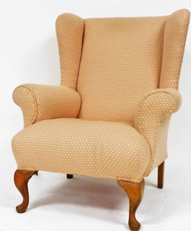 A Georgian style oak framed wingback armchair, upholstered in diamond pattern fabric, raised on cabriole legs.