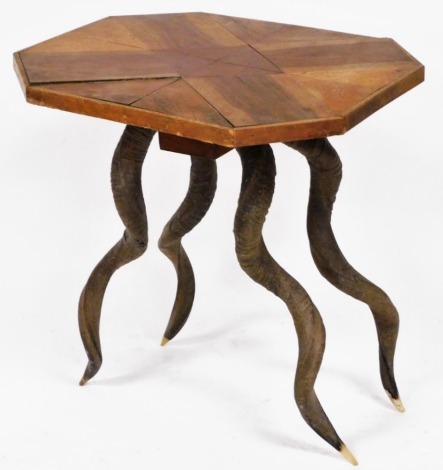 An octagonal parquetry topped table, raised on four antelope horns, 55cm high, 53cm wide, 44cm deep.