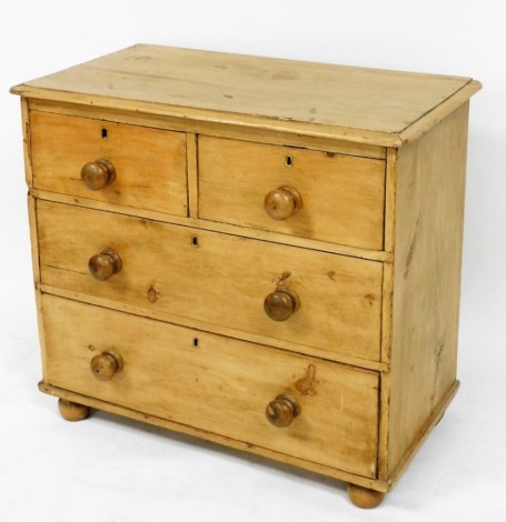 A Victorian pine chest, of two short over two long drawers, raised on bun feet, 74cm high, 84cm wide, 45cm deep.