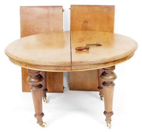 An Edwardian mahogany wind out dining table, with two additional leaves, raised on turned legs, brass capped on castors, 73cm high, 120cm wide, 218cm extended, 100cm deep.