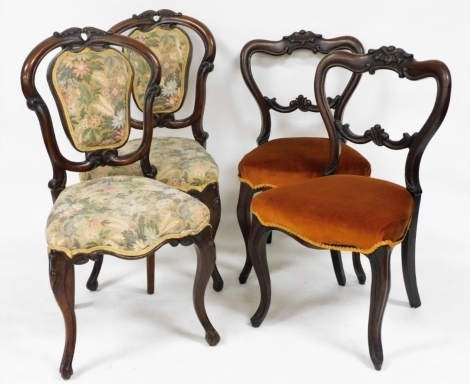 A pair of Victorian rosewood balloon back dining chairs, upholstered in overstuffed floral fabric, raised on cabriole legs, together with a further pair of Victorian rosewood dining chairs upholstered in overstuffed orange Draylon, raised on cabriole legs