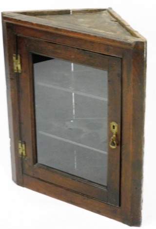 A 19thC oak wall hanging corner cupboard, with a glazed door revealing two shelves, 74cm high, 62cm wide, 32.5cm deep.