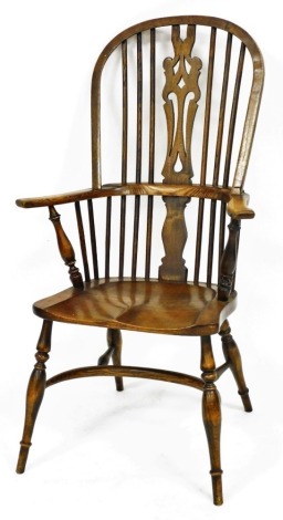 An ash and elm Windsor chair, with a pierced base shaped splat, solid saddle seat, raised on turned legs united by a crinoline stretcher.