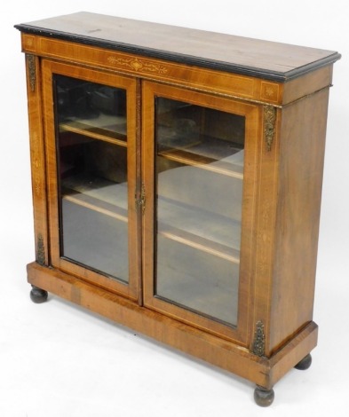 A Victorian walnut and inlaid pier cabinet, with a pair of glazed doors opening to reveal two shelves, raised on a plinth base over turned feet, 105cm high, 106cm wide, 52cm deep.