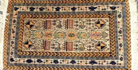 A Baluchi faun ground rug, decorated with guls and other stylised emblems, within repeating geometric borders, 188cm x 107cm.