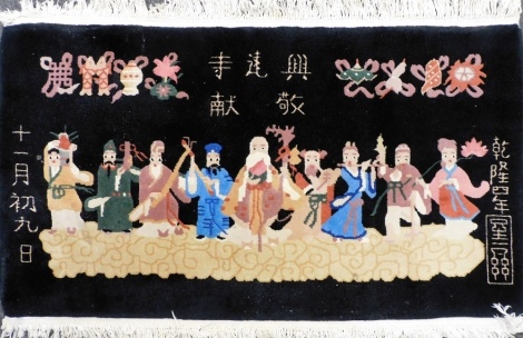 A Chinese black ground rug, decorated with nine immortals, beneath Buddhist symbols and script, 144cm x 84cm.