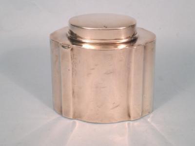 A silver tea caddy and cover