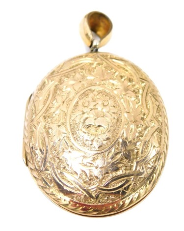 A Victorian locket, with floral scroll decoration and pendant loop top, vacant shield, silver gilt unmarked, 5cm high, 12g all in.