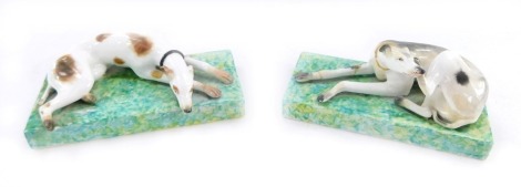 A pair of Stevenson & Hancock Derby porcelain greyhounds, each recumbent on a rectangular base, marks in red to underside, 5cm high, 13cm wide, (AF). (2)