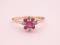 A tiny 9ct gold dress ring set with pink and white stones