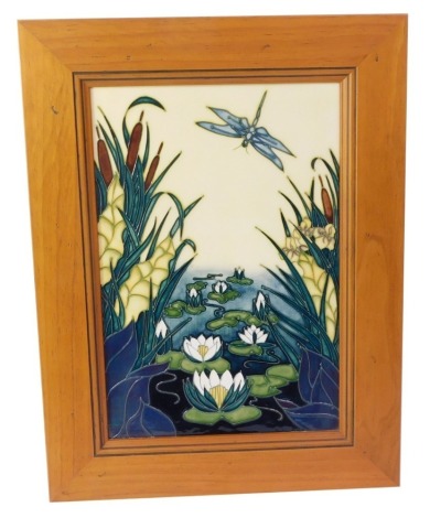 A Moorcroft Arts Studio panel, with lilies and dragonfly, signed Rachel Bishop dated 1995, with green Moorcroft stamp to underside, in pine frame, 42cm x 31.5cm.