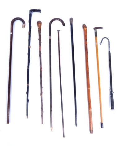 A collection of walking sticks, comprising three silver collared walking sticks, a carved Eastern inspired walking cane, black lacquer cane, etc. (8)