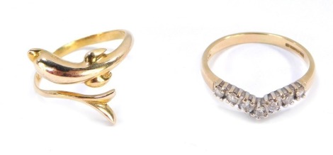 Two dress rings, comprising a dolphin twist ring, yellow metal stamped 585, ring size K, and a 9ct gold wishbone ring set with tiny diamonds, ring size N½, 4g all in. (2)