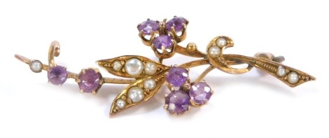 An amethyst and seed pearl bar brooch, formed as a floral spray, set in yellow metal unmarked, lacking back, 4cm wide, 1.8g all in.