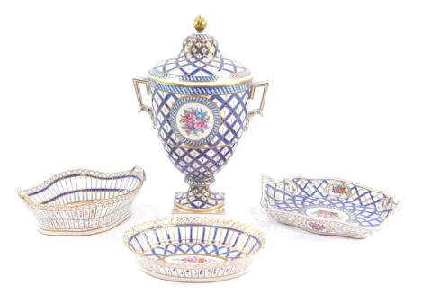 A group of Dresden China, comprising a jar and cover, with acorn finial top on a blue, gilt and white ground with painted floral sprays and two swing handles with modern blue Dresden stamp to underside, 38cm high, and three similar designed pierced rose b