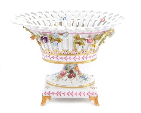 A Dresden porcelain basket, with applied flower detail, with gilt border on gilt stepped feet, bearing inscription Modet Et Decoration Exclusive A'La Main, 20cm high.