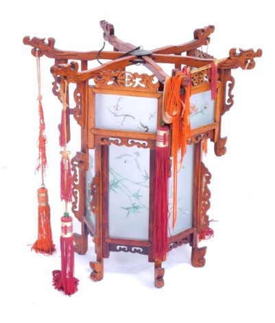 An oriental hardwood lantern, with six panels each with bird and flower panels, tassel ends, 45cm high.
