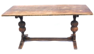 An oak refectory table, with two carved bulbous end supports, on tressle base, 74cm high, 168cm wide, 74cm deep.