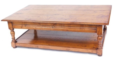 A varnished oak coffee table, with three planked top and single shelf base on column supports, 47cm high, 151cm wide, 90cm deep.