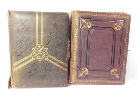 Two Victorian leather bound photograph albums, one with anchor design the other with central crest, in purple and brown leather with brass buckles.