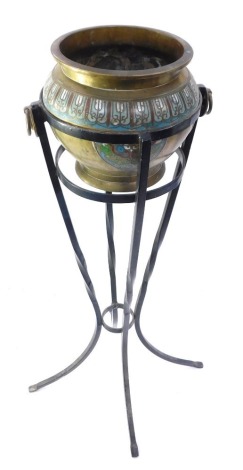 An Eastern champleve enamel and brass jardinere on stand, the pot picked out in green, blue, red and white detail, with two swing handles on associated wrought base, 72cm high.