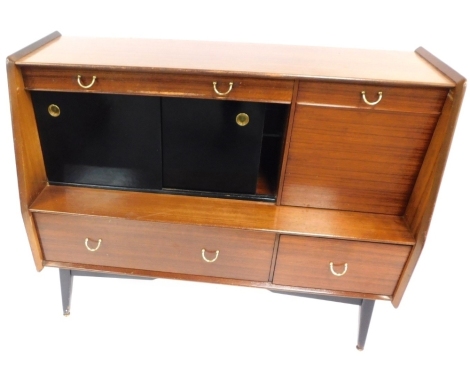 A G-Plan retro teak sideboard, with arrangement of one long and one short drawer, one cupboard door and sliding cocktail cabinet, on out splayed ebonised feet with brass capped supports, 95cm high, 121cm wide, 50cm deep.