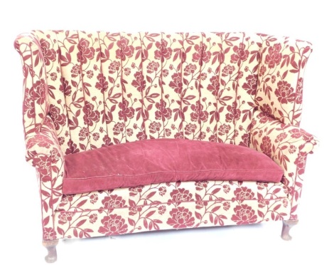 A high backed sofa, shaped arms, in plum and silver floral fabric, 105cm high, 147cm wide, 66cm deep. The upholstery in this lot does not comply with the 1988 (Fire & Fire Furnishing) Regulations, unless sold to a known exporter or upholsterer it will be 