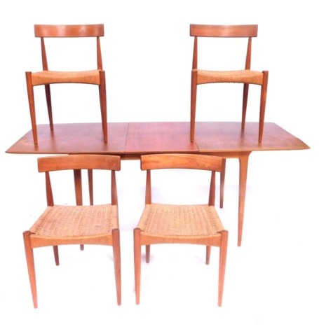 A G-Plan teak extending dining table, 74cm high, 146cm wide, 83cm deep, and a set of four rush seated chairs. (5)