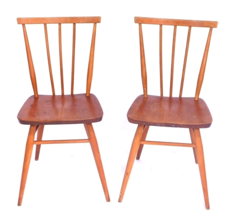 A pair of Ercol beech stick back kitchen chairs, each with registered design no 884923.