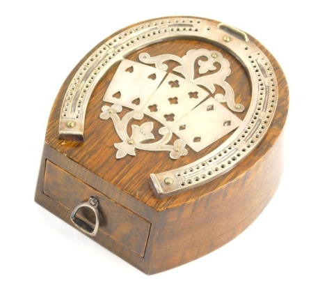 An Edwardian horseshoe shaped oak cribbage scorer, the silver plated mounts with pierced decoration of playing cards, with a frieze drawer containing a pack of cards, 16cm x 13.5cm.