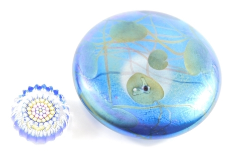 A Glasform paperweight, by John Ditchfield, lily pad design, signed with label beneath, 13cm diameter, and a Millefiori style paperweight of thistle head design, profusely decorated with flowers. (2)