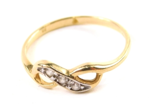 A dress ring, of figure of eight form set with four small white stones, on a white and yellow metal setting, partially pierced size N.