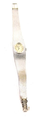 A 9ct white gold lady's Omega cocktail watch, the 1cm wide oval face with baton numerals and pointers, with textured bracelet marked .375, 29g all in.