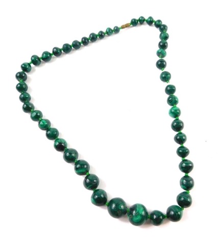 A graduated malachite bead necklace, with beads 6cm diameter, etc., on a plain string, 46cm long.