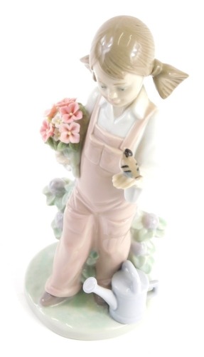 A Lladro figure of a child holding bird and flowers, number 5217, marked beneath, 20cm high.